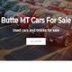 Used cars parked in a lot with a sign "Butte MT Cars For Sale."