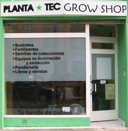 Fachada de tienda "Planta Tec Grow Shop" con lista de productos de cultivo en la ventana.
