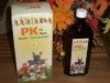 Eine Flasche PK Sirup und Verpackung mit Cartoon-Tieren, Herbstdekoration im Hintergrund.