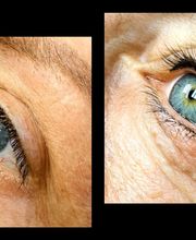 Close-up van twee blauwe ogen met donkere wimpers en lichte huid.