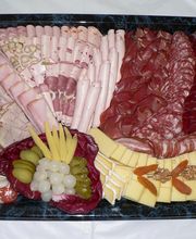 Wurst- und Käseplatte mit verschiedenen Sorten, dazu Obst und Nüsse als Dekoration.