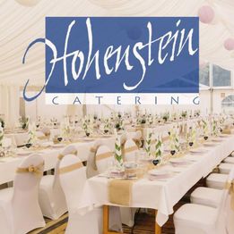 Elegante weiße Festzeltdeko mit gedeckten Tischen. "Hohenstein Catering" Schriftzug oben.