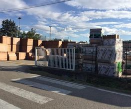 Materiali da costruzione impilati all'aperto vicino a una strada soleggiata.