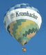 Heißluftballon mit "Krombacher"-Aufdruck fliegt am blauen Himmel.