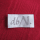 Etikett mit handgeschriebenem "d6/N" auf rotem Stoffhintergrund.