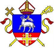 Wappen mit Lamm, Bischofsstab, Schwert und Mitra auf blauem und rotem Hintergrund.