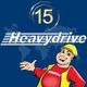 Zeichentrickfigur mit Bauhelm, daneben "Heavydrive"-Logo und "15 Jahre" auf blauem Hintergrund.