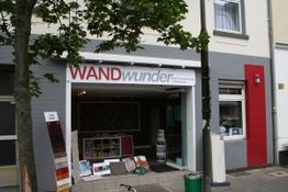 Außenansicht eines Geschäfts namens "WANDwunder", mit Malerbedarf vor dem Eingang.