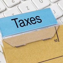 A file folder labeled "Taxes" on a keyboard.
