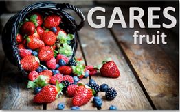Cesta de fresas, arándanos y moras sobre la mesa de madera. Texto: GARES fruit.