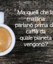 Tasse Kaffee auf Holztisch, daneben italienischer Text über morgendliche Gespräche ohne Kaffee.