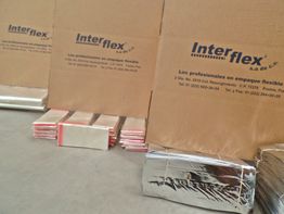 Cajas de cartón y paquetes envueltos en material plateado de la marca Interflex.