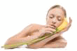 Frau hält gelbe Blume, weißer Hintergrund, entspannte Pose.