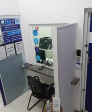 Sala de câmbio com balcão de atendimento, cartazes na parede e ambiente branco e azul.