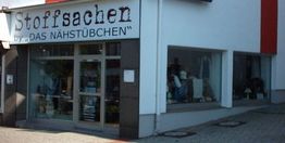 Geschäftsfassade mit Schild "Stoffsachen by DAS NÄHSTÜBCHEN". Glasfenster und Eingangstür sichtbar.