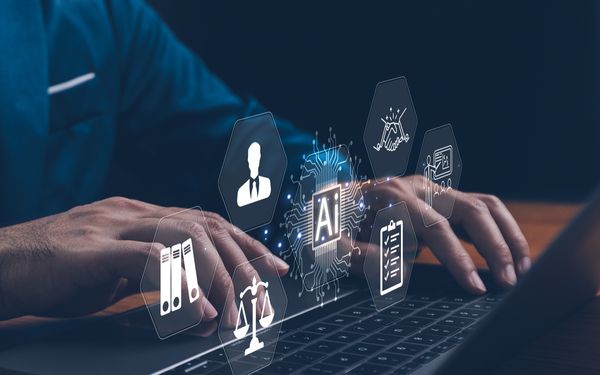 Mann sitzt vor Laptop mit Symbolen vor ihm