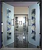 Zwei geöffnete Glastüren mit blauen Mustern, spiegelnder Boden, drittes Glas im Hintergrund.