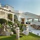 Villa elegante con giardino curato, amaca e vista sul mare in lontananza.