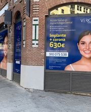 Fachada con anuncios de clínica dental ofreciendo implantes y coronas por 630€ en Madrid.