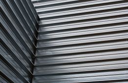 Corrugated metal sheets forming an angular, textured architectural pattern.