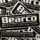 "Black and white BearcoTraining.com stickers in a scattered pile."