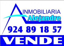 Letrero de Inmobiliaria Alejandre en azul y blanco con número de teléfono y texto "VENDE".