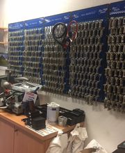 Werkstatt mit Schlüsseln an der Wand, Maschinen und Zubehör auf Schränken.