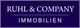 Blaues Logo mit weißem Text: "Ruhl & Company Immobilien".