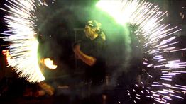 Person zeigt Feuerkunststück mit Funkenring.