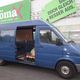 Blauer Lieferwagen mit offener Schiebetür vor einem Möbelgeschäft.