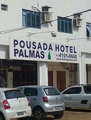 Fachada da Pousada Hotel Palmas com carros estacionados em frente.
