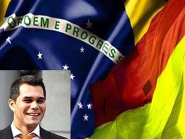 Bandeira do Brasil ao fundo, com sorriso de homem em destaque na parte inferior esquerda.