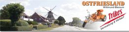 Straßenansicht mit Windmühle in Ostfriesland, Werbung für Trike-Verleih und Verkauf.