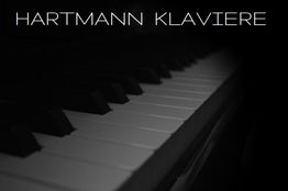 Nahaufnahme einer Klaviertastatur mit dem Text "Hartmann Klaviere" darüber.