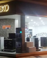 Tienda ILEKO iluminada, con electrodomésticos en exhibición y grandes ventanas de vidrio.