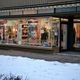 Friseursalon mit großen Werbepostern im Winter. Schneebedeckter Gehweg vor dem Geschäft.