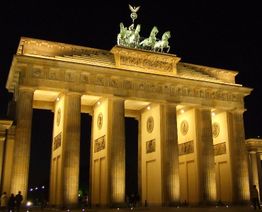 Beleuchtetes Brandenburger Tor bei Nacht, mit Quadriga obenauf, in Berlin.