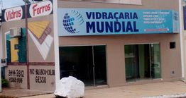 Fachada de loja "Vidraçaria Mundial" com ofertas de vidros e forros, e telefone para contato.