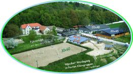 Luftaufnahme eines Pferdehofs mit Reitanlagen, Boxen, Aktivstall und Weideflächen in grüner Umgebung.