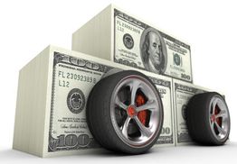 Stacks of hundred-dollar bills shaped like a car with wheels.