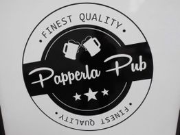 Logo mit Text "Papperla Pub" und "Finest Quality", zwei Bierkrüge und Sterne im Kreis.