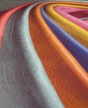 Telas de varios colores vibrantes enrolladas formando un patrón ondulado y estético.