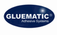 Blaues Logo mit weißem Text "GLUEMATIC Adhesive Systems" auf ovalem Hintergrund.