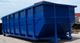 A large blue industrial dumpster sits outdoors on a concrete surface.
