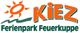 Logo des KIEZ Ferienparks Feuerkuppe mit Sonne und Wellen in orange und grün.