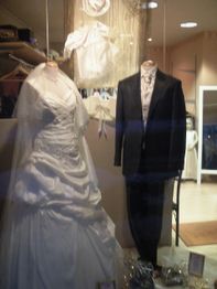 Brautkleid und Anzug in einem Schaufenster ausgestellt.
