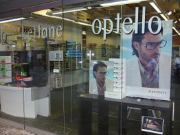 Optikergeschäft mit Brillenwerbung und Schriftzug "optello" auf der Glasfassade.