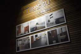 Wand aus Holzverkleidung mit "Tiles-4U" und Badezimmer-Bildern an der Wand dargestellt.