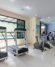 Sala de academia com esteiras, bicicletas ergométricas e aparelhos de musculação.