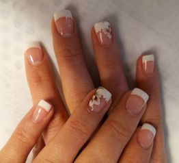 French Manicure auf Fingernägeln, einer mit Blumenmuster verziert.